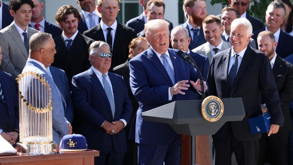 US President Donald Trump (C) delivers remarks alongside Los Angeles Dodgers owner and Chairman Mark Walter (R) as he hosts the 2025 MLB World Series champion Los Angeles Dodgers in the Rose Garden of the White House on July 23, 2026, in Washington, DC. (