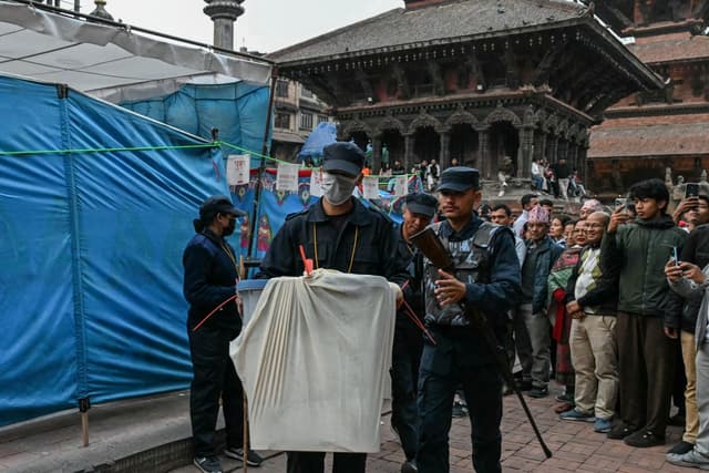 Security personnel and electoral officials carry ballot boxes to the counting centre after voting ends at a polling station during Nepal's general election in Lalitpur on March 5, 2026. (AFP)