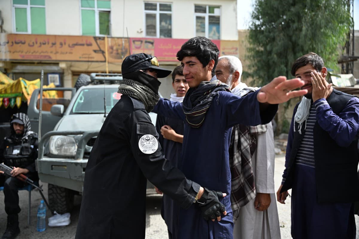 A Taliban security personnel frisks Afghans along a road in Kandahar on June 26, 2026. (AFP)