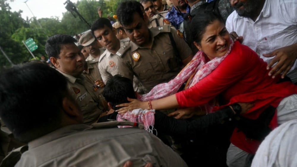Security personnel detain India's opposition party Indian National Congress (INC) member Alka Lamba (R) as she takes part in a sit-in protest calling for Prime Minister Narendra Modi's resignation outside the latter's residence in New Delhi on July 21, 20