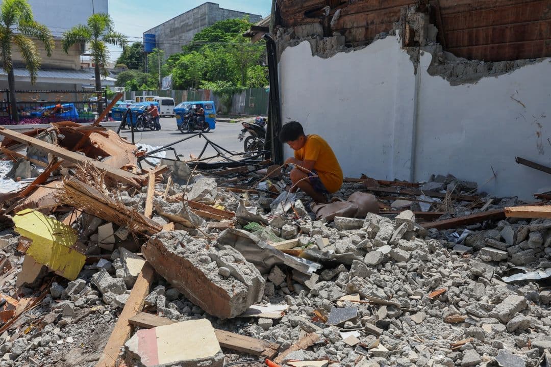 A man searches for salvageable belongings in the debris of his collapsed home following a deadly earthquake in General Santos, Philippines, on June 10, 2026. (AFP)