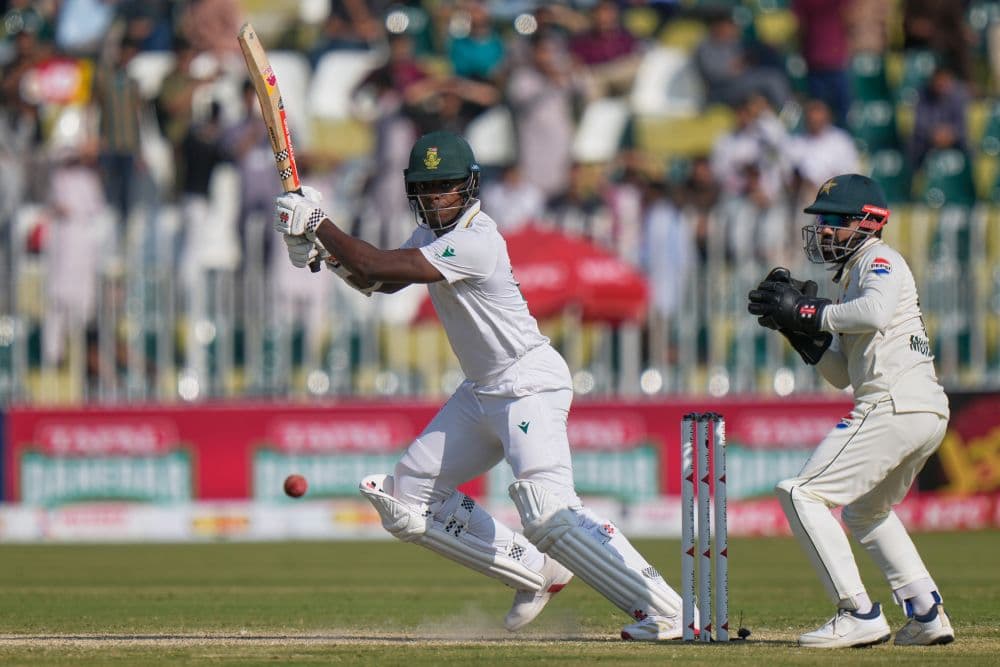South Africa's Kagiso Rabada, left, plays a shot as Pakistan's Mohammad Rizwan watches during the third day of the second test cricket match between Pakistan and South Africa, in Rawalpindi, Pakistan, October 22, 2025. (AP)