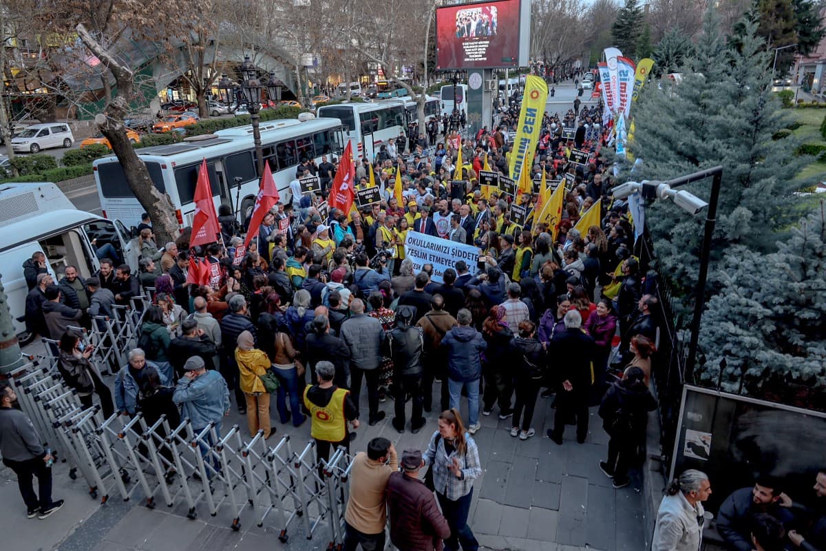 Members of education unions chant slogans as they hold a banner which reads "We will not surrender our schools to violence" during a protest against school shootings in front of the Ministry of National Education headquarters in Ankara on April 15, 2026.