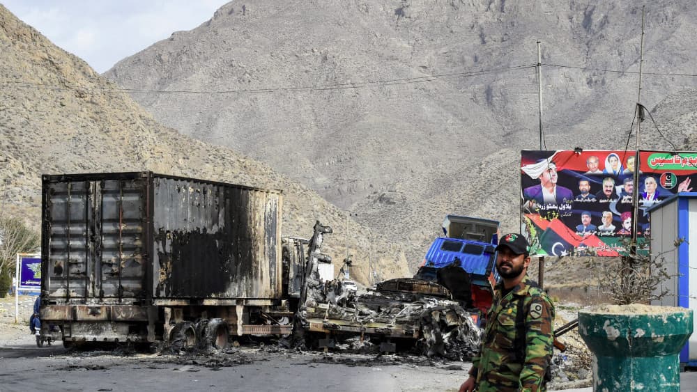 A security personnel stands guard near charred truck containers torched by armed terrorist group Balochistan Liberation Army (BLA) at central Bolan district in Balochistan province on January 30, 2024.