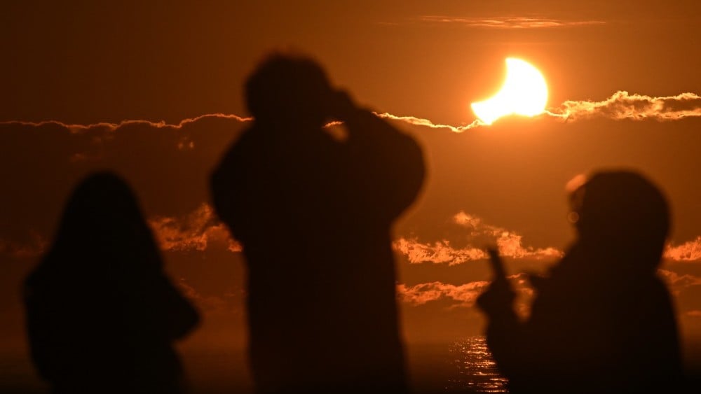 People watch a partial solar eclipse at New Brighton, a coastal suburb of Christchurch, on September 22, 2025. (File photo: AFP)