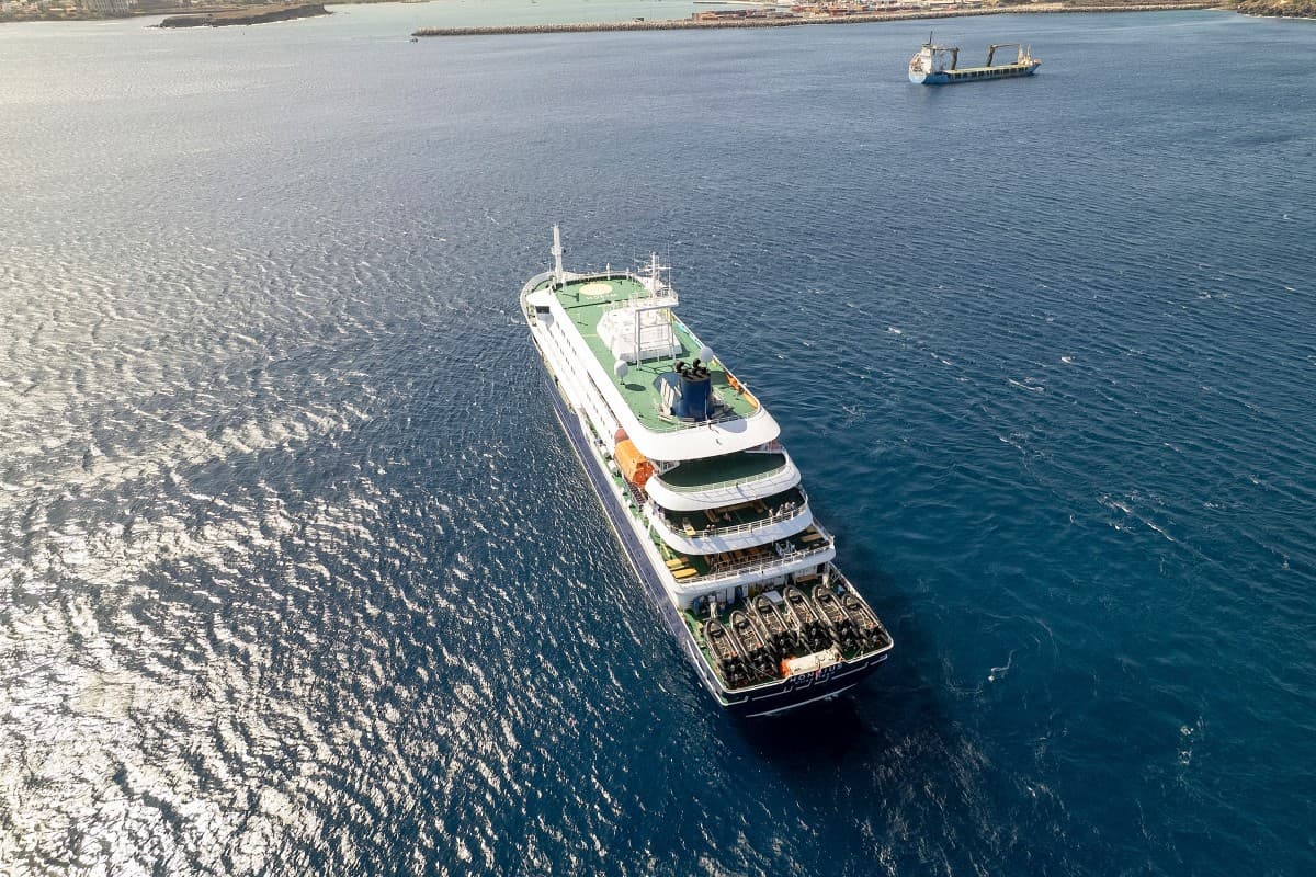 This aerial picture shows a general view of the cruise ship MV Hondius stationary off the port of Praia, the capital of Cape Verde, on May 3, 2026. An outbreak of "severe acute respiratory illness" on board a cruise ship in the Atlantic has left two peopl