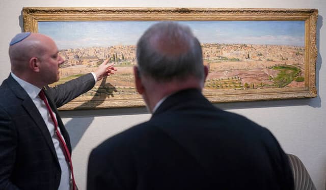 US Ambassador to Israel Mike Huckabee (R) is shown a painting of Jerusalem during a visit to the Beit Hanassi presidential residence, in Jerusalem, on September 15, 2025. (AFP)