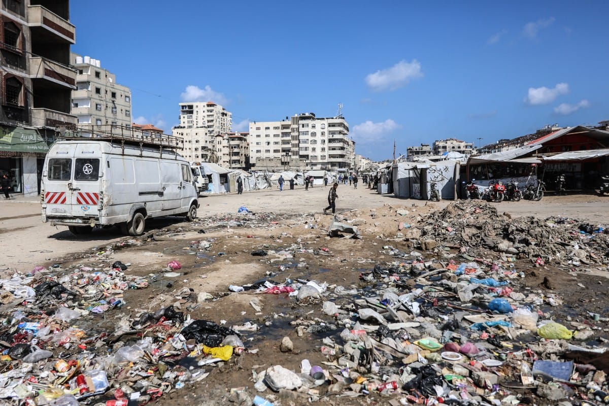 Garbage litters the ground next to makeshift shelters housing displaced Palestinians in Gaza City on April 20, 2026. (AFP)