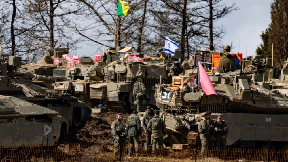 Israeli army soldiers are seen among military vehicles in the Upper Galilee in northern Israel near the border with Lebanon on March 16, 2026.