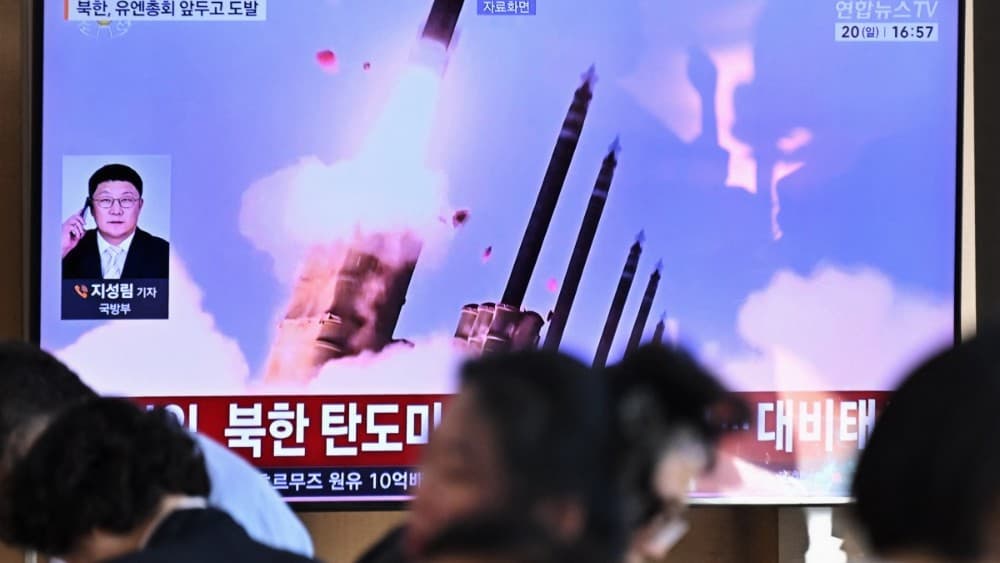People sit near a television screen showing a news broadcast with file footage of a North Korean missile test at a train station in Seoul on September 20, 2026. (Photo: AFP)