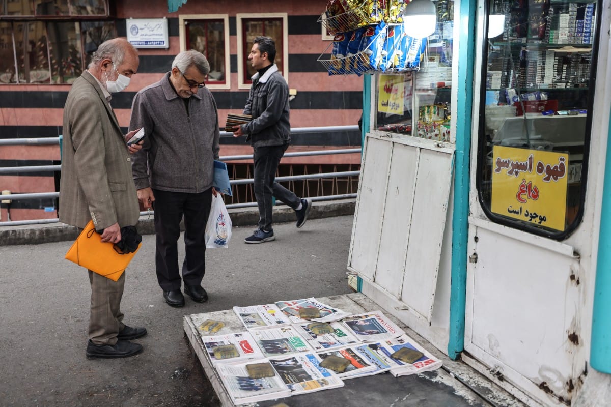 Men look at Iranian daily newspapers reporting on the first round of talks between Iran and the United States at a kiosk in Tehran. (AFP)