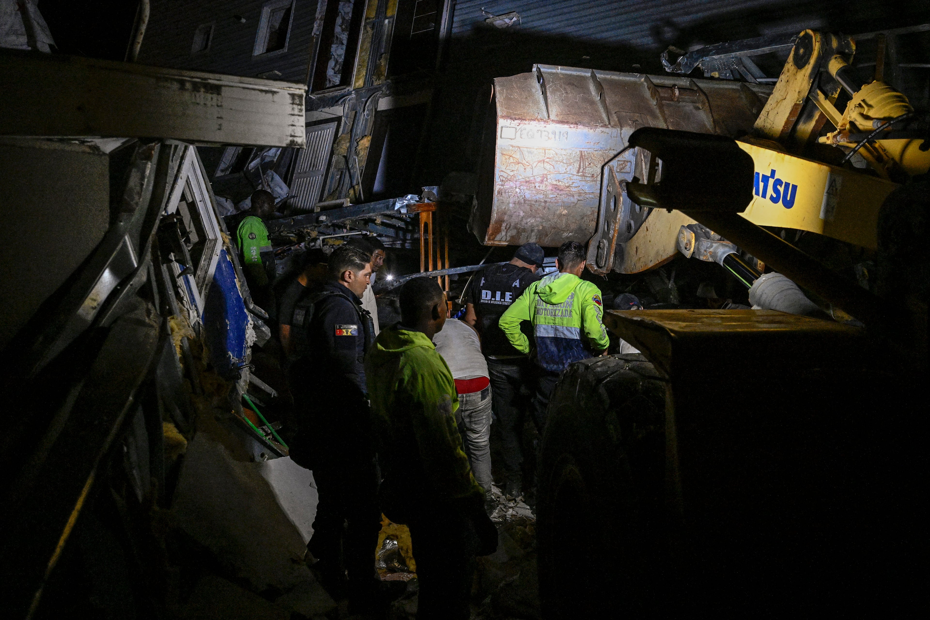 Police and volunteers search for people in a damaged building following an earthquake in Catia La Mar, La Guaira state, some 30km north-west of Caracas, early on June 25, 2026.