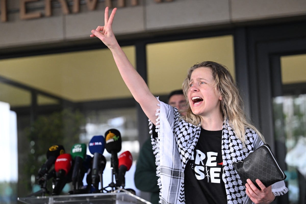 A member of the Global Sumud Flotilla headed for Gaza and arrested and deported by Israel flashes the V-sign outside a terminal following their arrival at Istanbul Airport on May 21, 2026. (AFP)