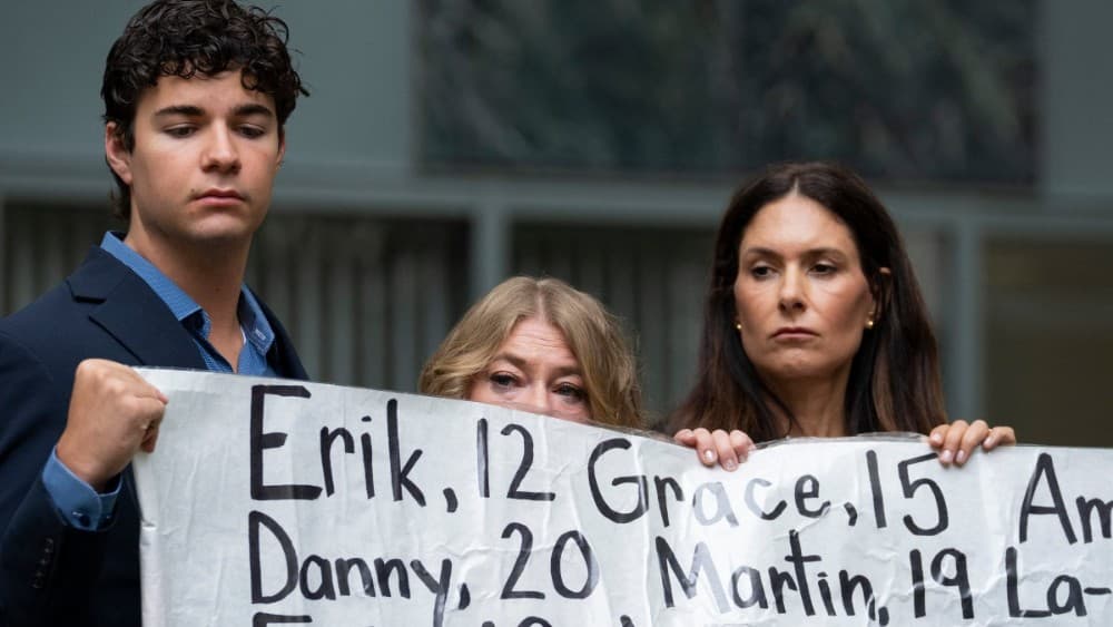 Dawson Kelly, Victoria Hinks and Lisa Pearson hold a banner with the names of nearly 400 young people who allegedly died from the impacts of social media outside the Ronald V. Dellums Federal Building & United States Courthouse in Oakland, California, on