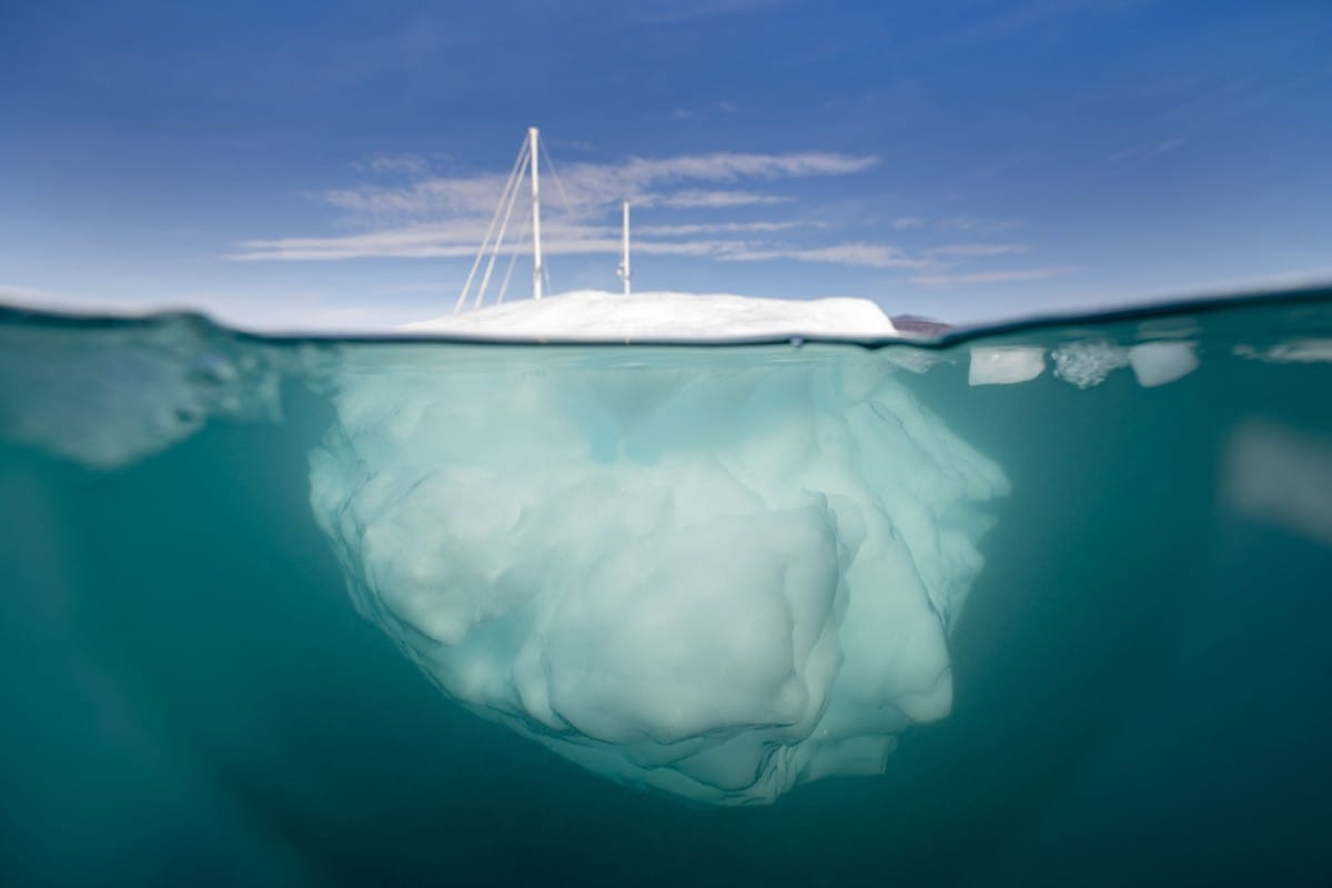 The Greenlandia expedition's sailing boat 'Kamak' sails between icebergs released by glaciers around Milne Land in the Scoresby Sound Fjord, Eastern Greenland, on August 15, 2023. (AFP)