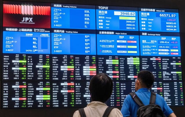 Visitors look at electronic display boards showing stock prices and economic indicators at the Tokyo Stock Exchange in Tokyo on June 1, 2026. (Photo by Kazuhiro NOGI / AFP)
