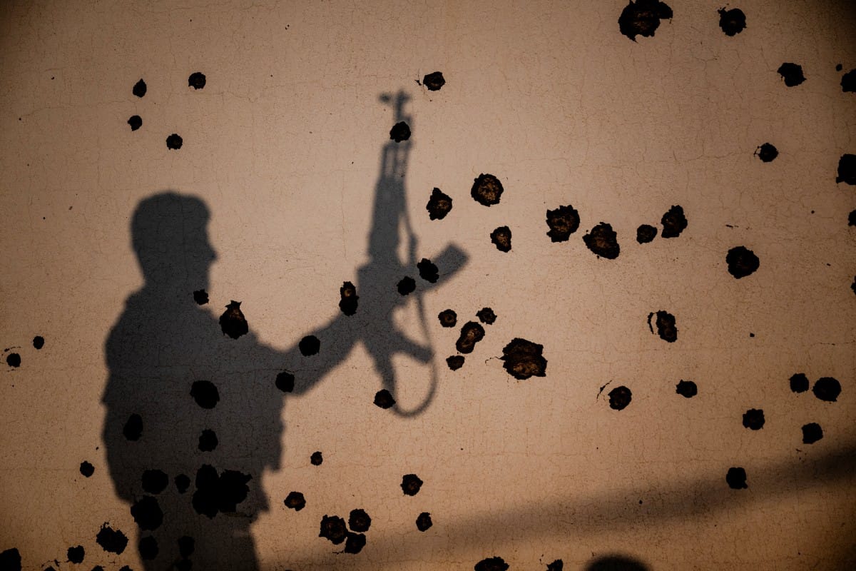 The shadow of a fighter falls on the shrapnel scarred wall of a damaged building, following an Iranian drone attack near Erbil, in Iraq's northern autonomous Kurdish region on March 9, 2026. (AFP)
