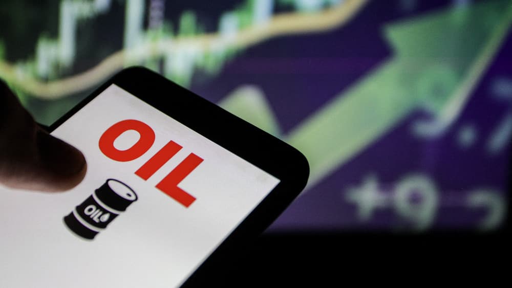 Close up image of a smartphone displaying an oil symbol in front of financial market charts illustrating the rise in global oil prices linked to tensions between Iran and the United States in Tunis, Tunisia on June 11, 2026. (AFP)