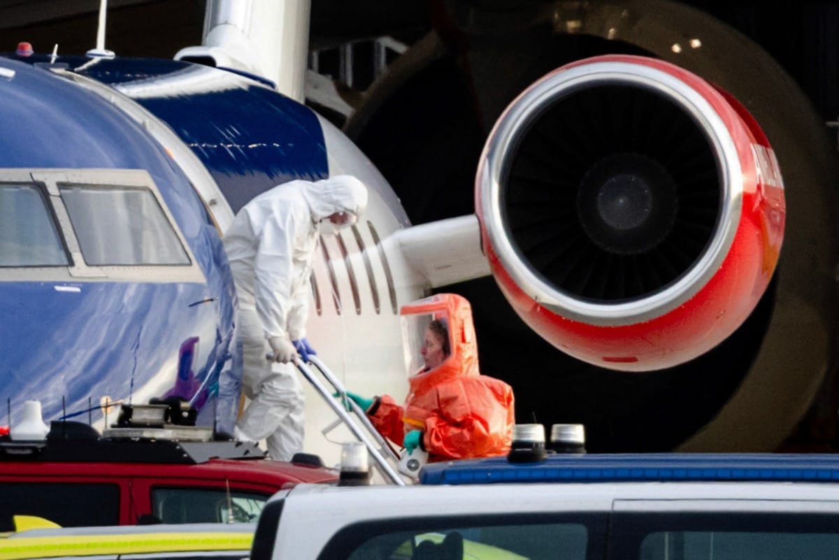This photograph shows a person in a white hazmat suit disembarking a Bombardier Challenger 605 medical aircraft allegedly carrying some of the passengers believed to be infected with hantavirus from the cruise ship MV Hondius, before being escorted to an
