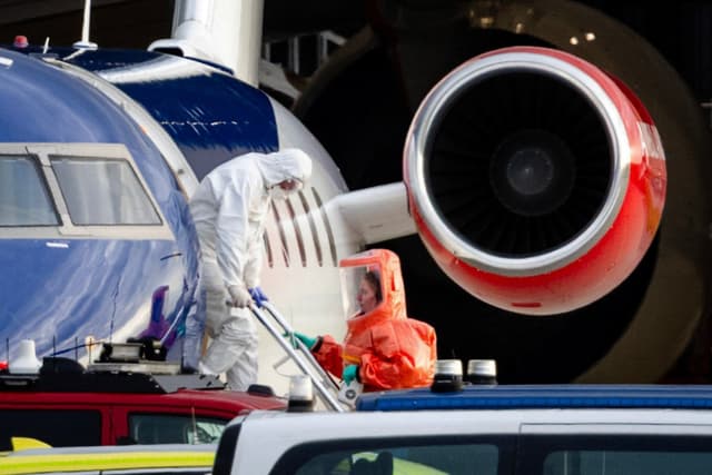 This photograph shows a person in a white hazmat suit disembarking a Bombardier Challenger 605 medical aircraft allegedly carrying some of the passengers believed to be infected with hantavirus from the cruise ship MV Hondius, before being escorted to an