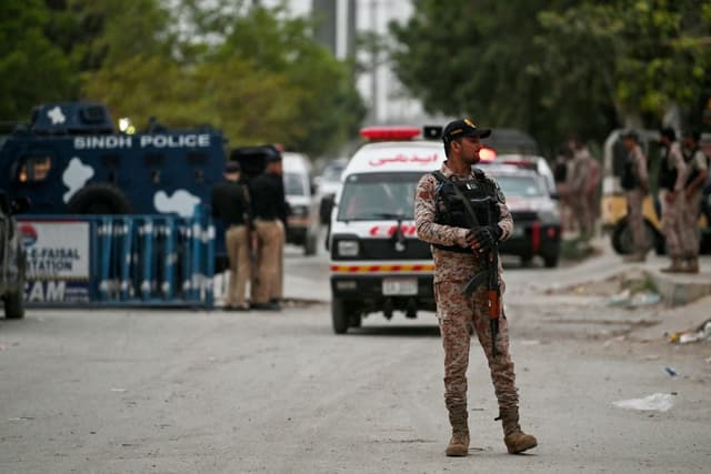 A security personnel stands guard at the end of a clearance operation following an explosion and a terrorist attack in Karachi on June 28, 2026. (AFP)