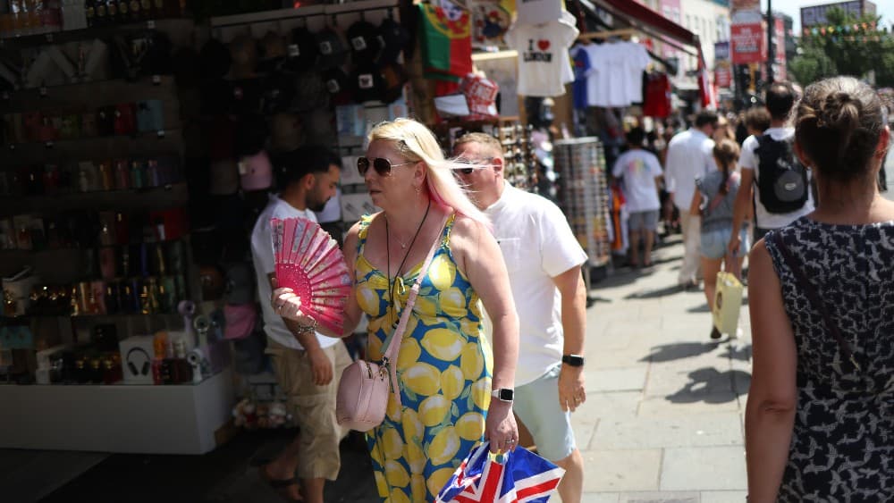 A shopper uses a fan while visiting Camden in central London on June 27, 2026, during a heatwave.