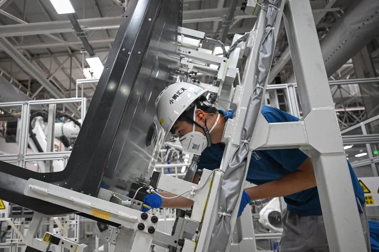 An employee works on a production line for electric flying car “Land Aircraft Carrier” at a factory of Xpeng's subsidiary Aridge in Guangzhou, in southern China's Guangdong province on November 6, 2025. (Photo by Jade GAO / AFP)