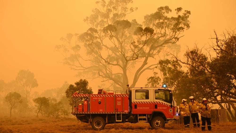 Firefighters protect a property from bushfires burning near the town of Bumbalong south of Canberra on February 1, 2020.