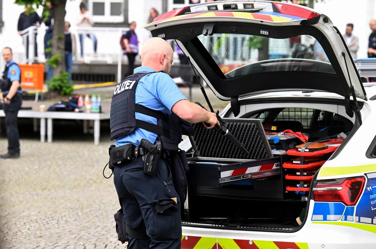 A police officer stows away a firearm in the trunk of a police car following the robbery and hostage situation at a bank in Sinzig, western Germany on May 8, 2026. (AFP)