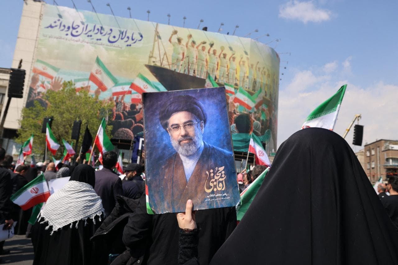 A mourner holds a picture depicting Iran's supreme leader Mojtaba Khamenei during the funeral of Iran's security chief Ali Larijani and Gholamreza Soleimani, a senior officer in the Islamic Revolutionary Guard Corps who commands Basij forces, in Tehran on