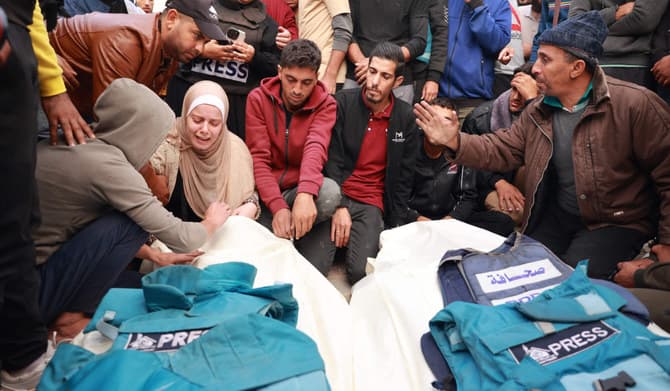File Photo - Relatives and colleagues of two Palestinian journalists Hasouna Slim and Sari Mansoor, killed in an Israeli strike, mourn over their bodies during their funeral in Deir al-Balah in the southern Gaza Strip on November 19, 2023. (AFP)