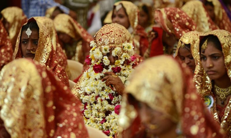 File: This picture shows an Indian bride with her face covered with flower garlands during a mass wedding ceremony in Ahmedabad, India. (AFP)