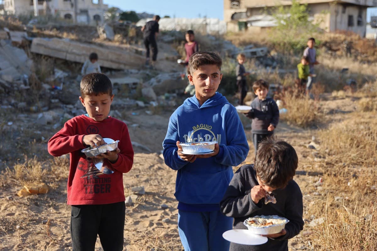 Displaced children carry food packets being distributed by Palestinian sisters Lina Zeid and Aya Zeid as a charity in the Al-Tuam area, west of Jabalia in the northern Gaza Strip on May 6, 2026.