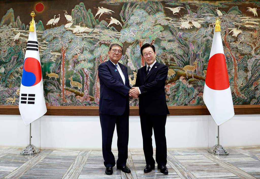South Korean President Lee Jae Myung, right, shakes hands with Japanese Prime Minister Shigeru Ishiba during a meeting in Busan, South Korea