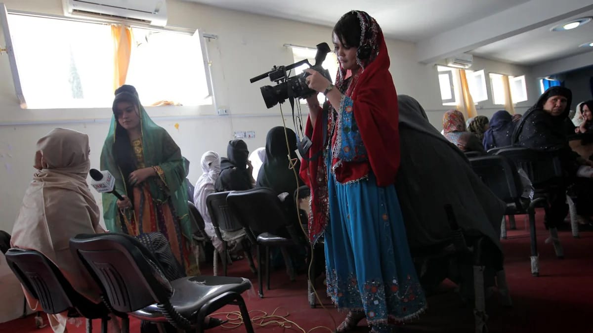 Afghan journalists interview a woman for state-run Radio Television Afghanistan (RTA) during a ceremony to mark International Women's Day in Helmand province's Lashkar Gah on March 8, 2010. (AFP)
