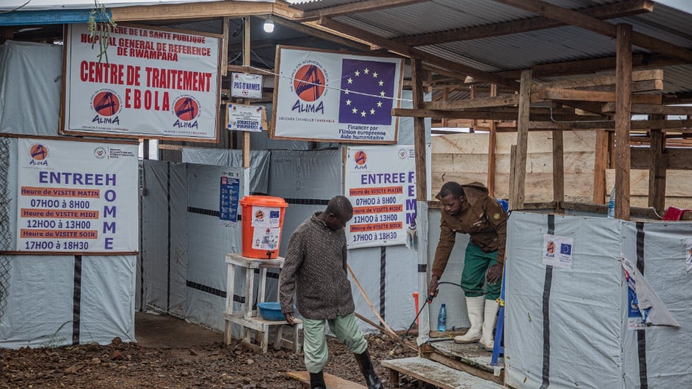 A hygiene worker disinfects a person's feet at the entrance to the Rwampara Ebola Treatment Centre (ETC) in Bunia, Ituri, in the east of the Democratic Republic of Congo on July 13, 2026.
