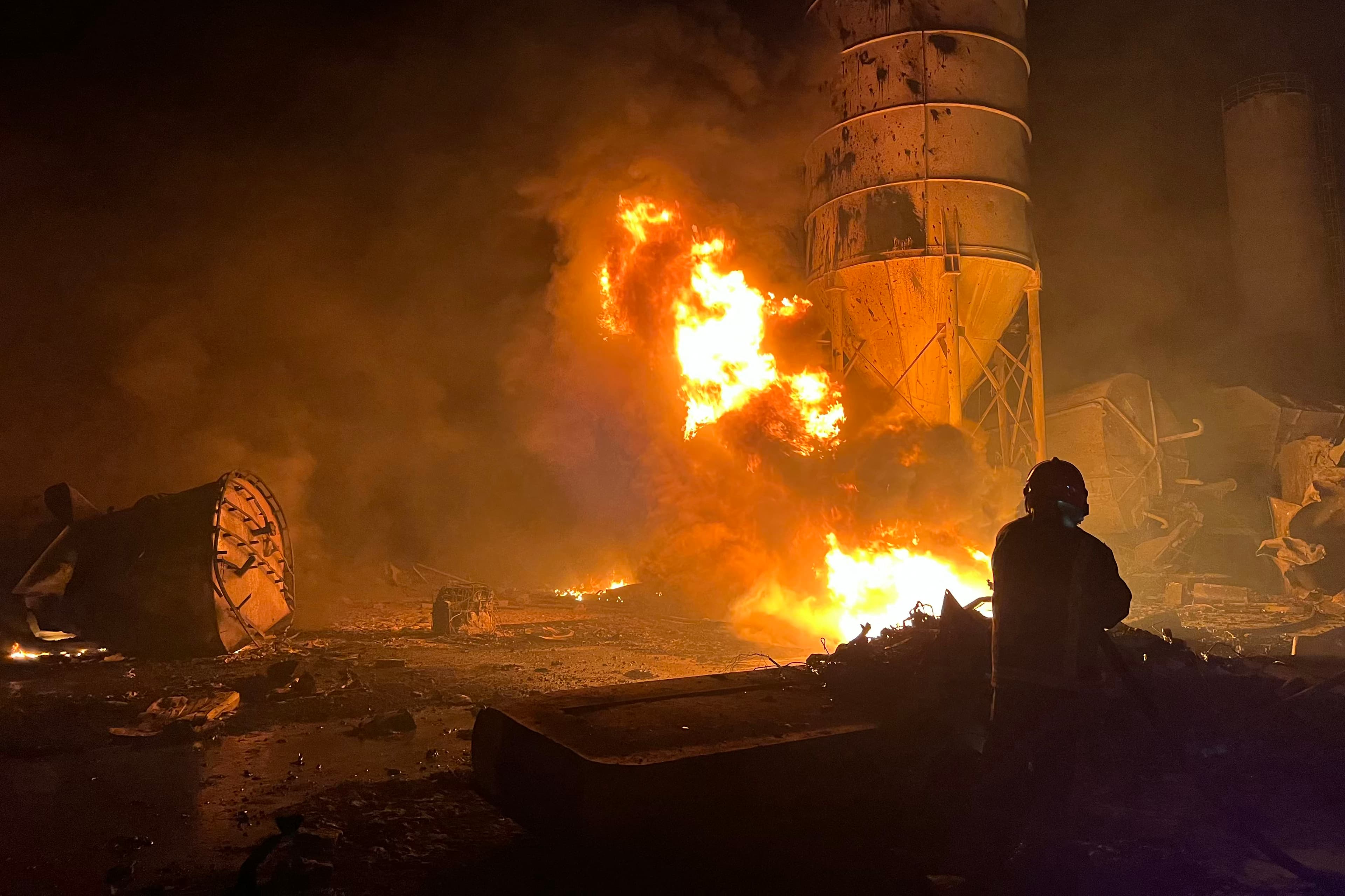 A firefighter douses flames at a cement factory after Israeli airstrikes in Ansar, near Doueir, southern Lebanon, on Oct. 16, 2025. Lebanon’s Health Ministry said the strikes killed one person and wounded seven. (AP Photo/Name)