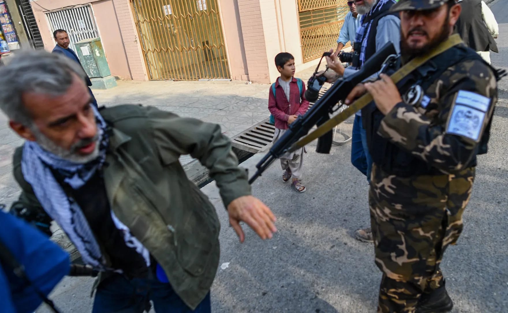 A member of the Taliban special forces pushes a journalist (L) covering a demonstration by women protestors outside a school in Kabul on September 30, 2021. (AFP)