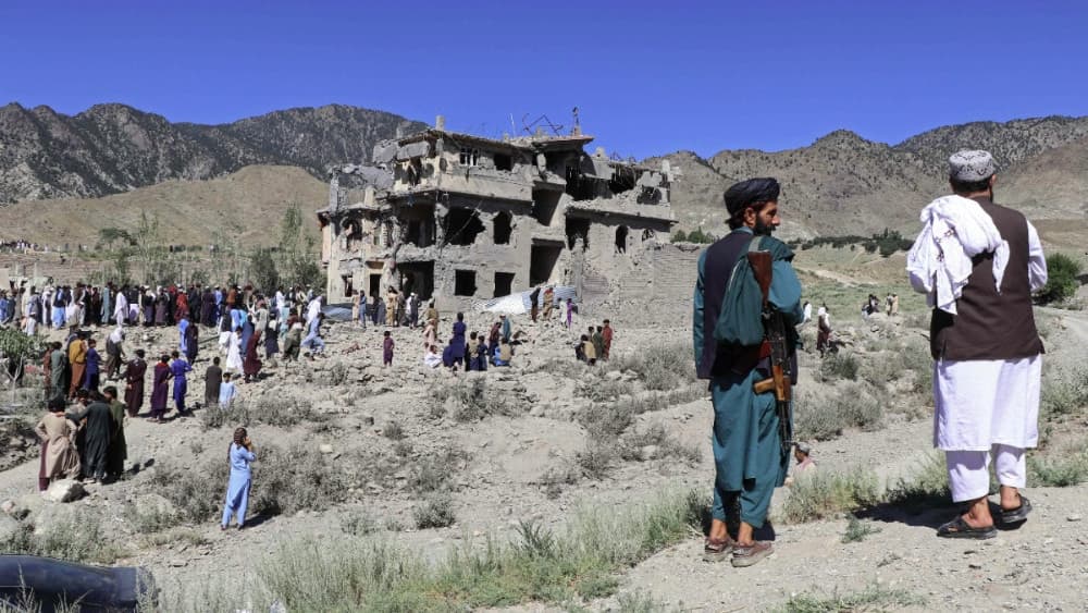 Afghan residents and a Taliban security personnel gather in Tsamkani district of Afghanistan's Paktia province on June 29, 2026. (AFP)