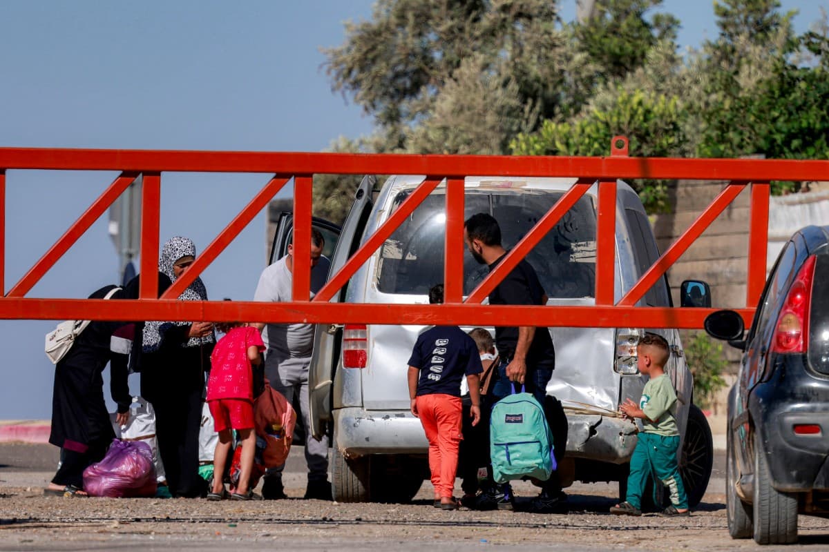 People cross the barrier at the entrance of the Palestinian village of Qusra, south of Nablus in the occupied West Bank, to enter a vehicle on June 30, 2026, as the barrier is closed by Israeli forces. (Photo: AFP)