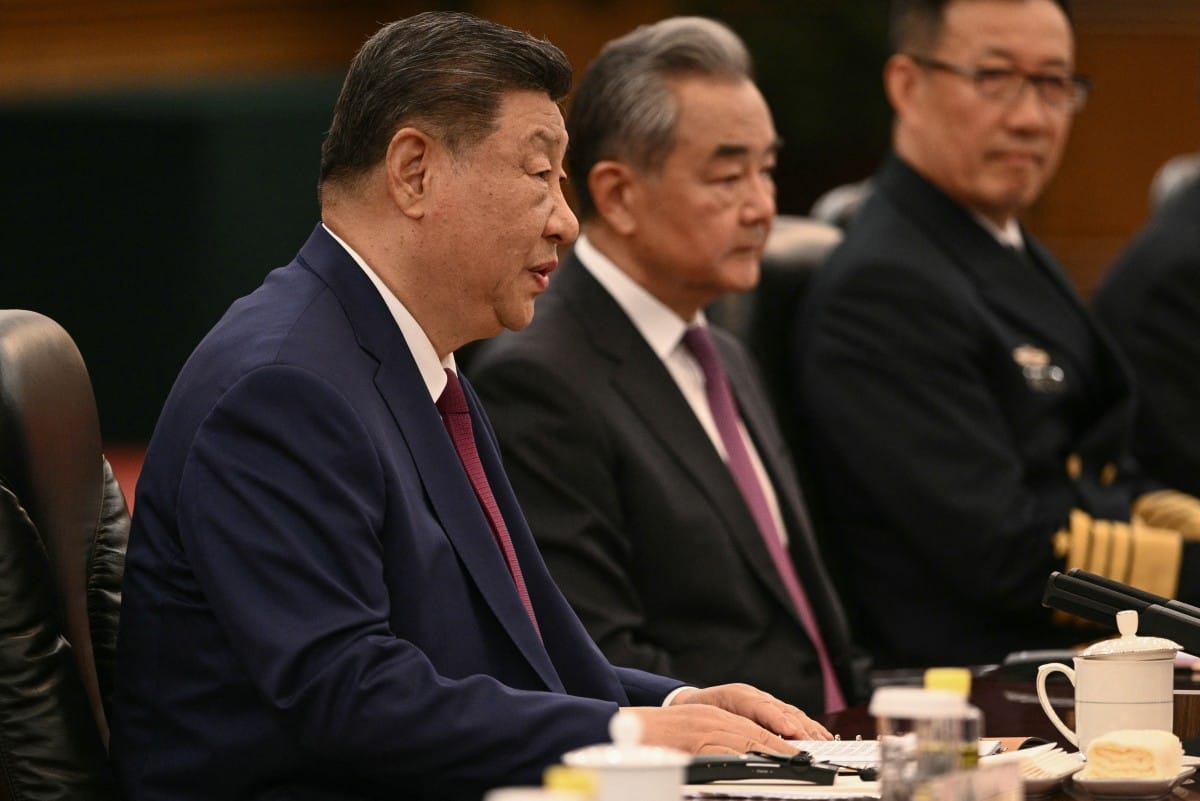 China's President Xi Jinping (L) speaks next to China's Foreign Minister Wang Yi (2nd L) during a meeting at the Great Hall of the People in Beijing on May 14, 2026. (Photo by Brendan SMIALOWSKI / AFP)