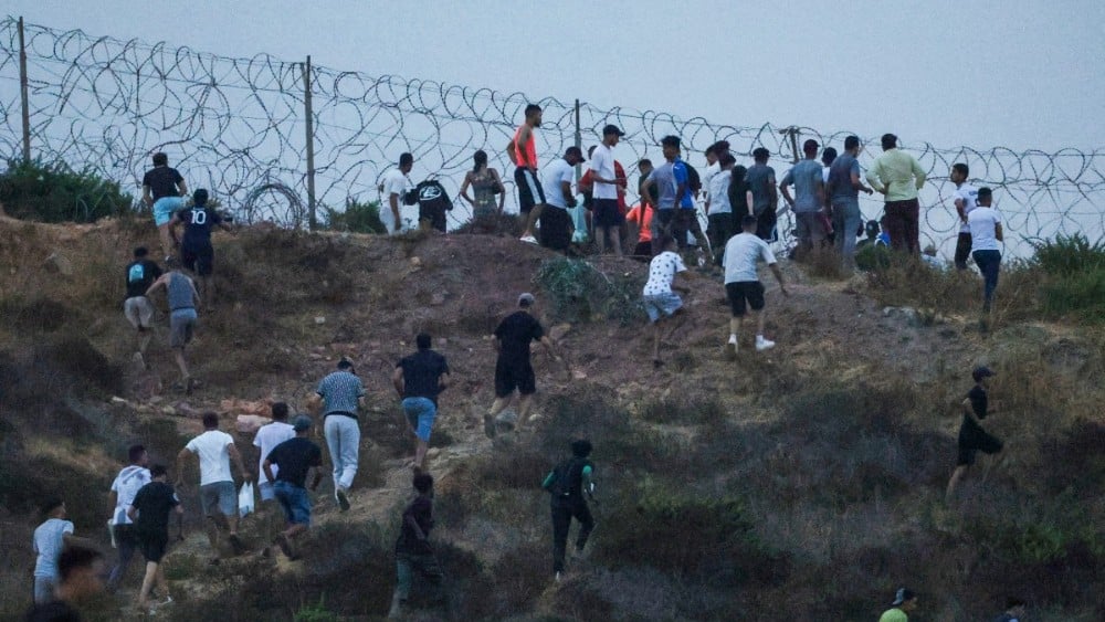 People gather on a hilltop near Bab Sebta on the Morocco-Spain border, near Spain's enclave of Ceuta and the Moroccan town of Fnideq on July 30, 2026 (AFP)