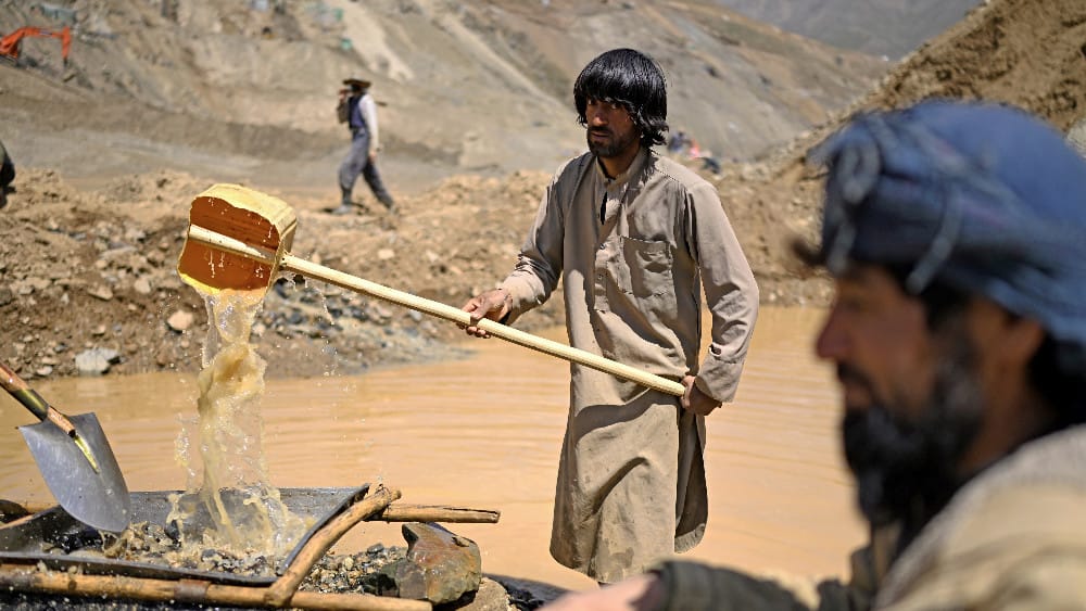 This photograph taken on July 28, 2026 shows an Afghan miner pouring water over a sieve to separate dirt and stones from gold nuggets at Gulak-Dara valley in Shiwa area of Afghanistan's northeastern Badakhshan province. (AFP)