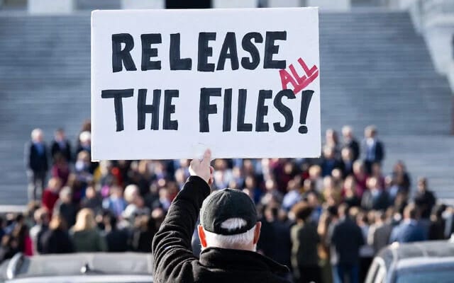 A protester holds a sign related to the release of the Jeffrey Epstein case files outside the US Capitol in Washington, DC, November 12, 2025 (SAUL LOEB / AFP)