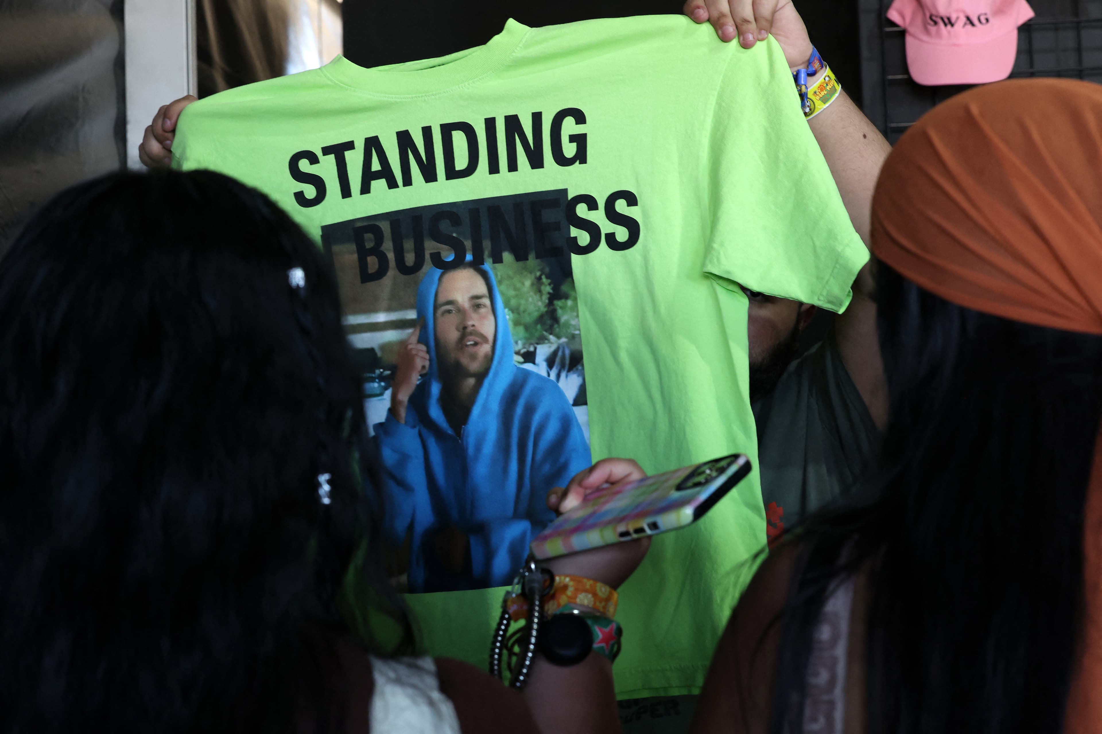 An employee shows a Justin Bieber shirt to a fan during during the 2026 Coachella Valley Music and Arts Festival in Indio, California on April 11, 2026. (AFP)