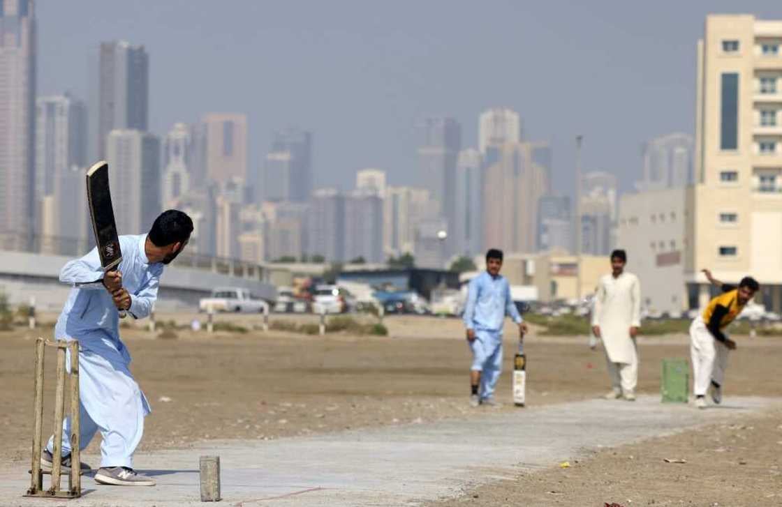 Pakistani workers play cricket in an industrial zone in the Gulf emirate of Sharjah, during their day off from work, on September 24, 2022. (AFP)