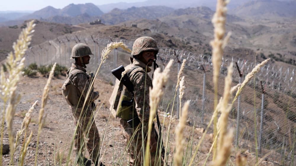 Pakistani soldiers keep vigil next to a newly fenced border fencing along Afghan border at Kitton Orchard Post in Pakistan's North Waziristan tribal agency. (AFP)