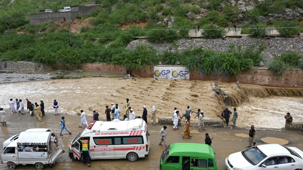 Commuters wait as floodwater swamps a road following heavy monsoon rains at Landi Kotal in Pakistan's Khyber Pakhtunkhwa province on July 20, 2026. (Photo by Abdul MAJEED / AFP)