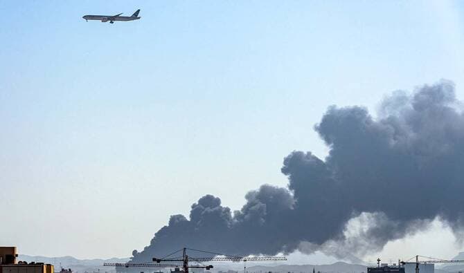 FILE: A Pakistan International Airlines (PIA) aircraft flies above as smoke rises from a Saudi Aramco oil facility in Saudi Arabia's Red Sea coastal city of Jeddah, on March 26, 2022. (Photo by Andrej ISAKOVIC / AFP)