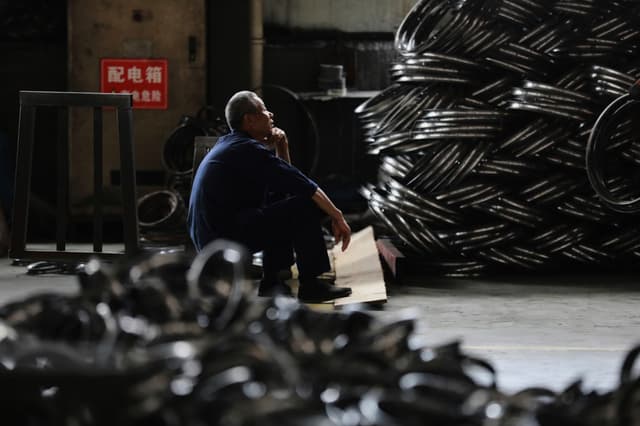FILE - A worker takes a rest at a factory making steel bike rims for export to U.S., in Hangzhou in east China's Zhejiang province, on Friday, April 11, 2025.